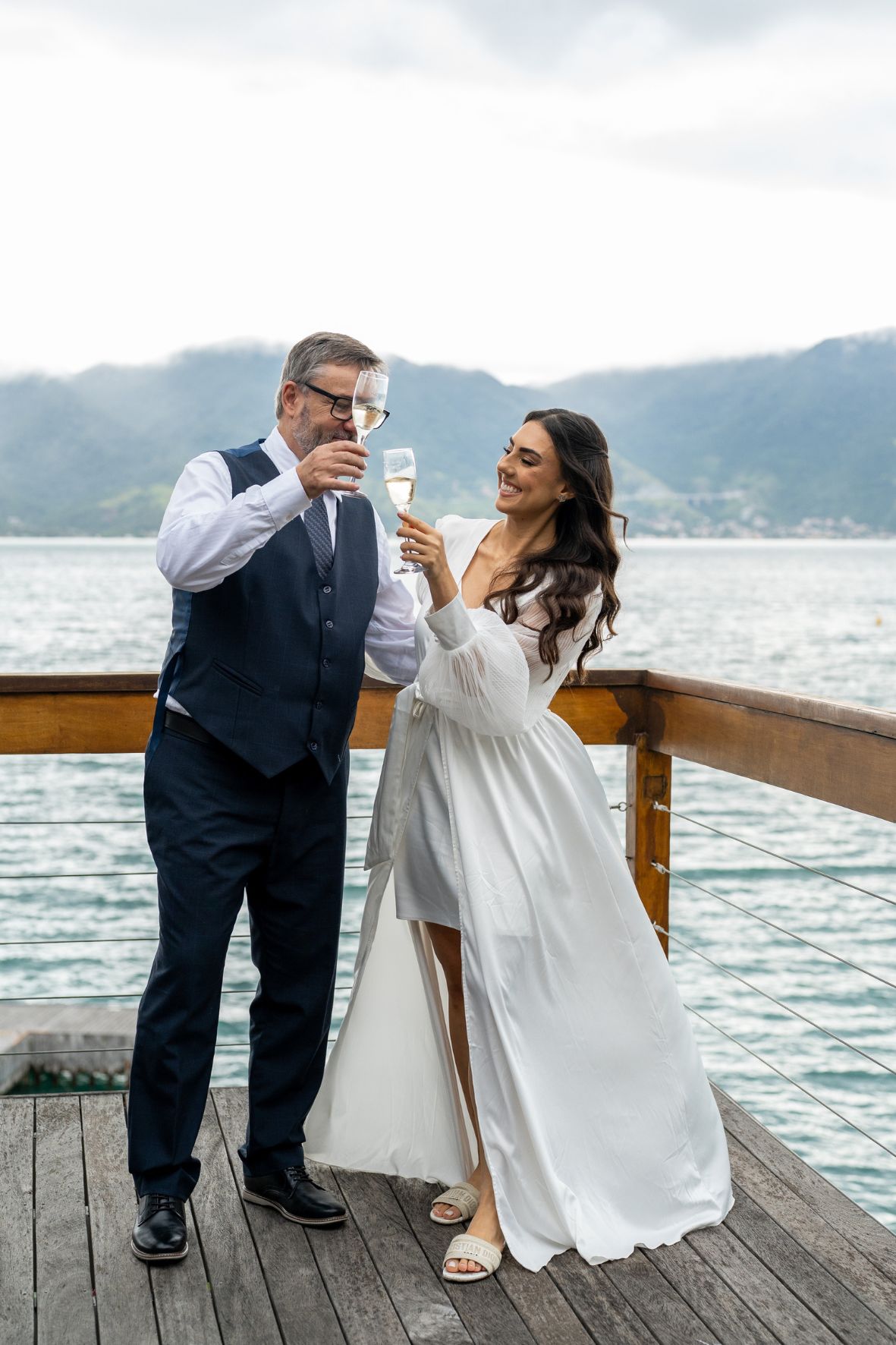 noiva e pai brindando na praia